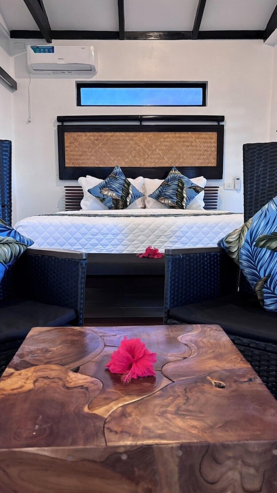 The Luxury Villa — bedside flowers and wicker chairs