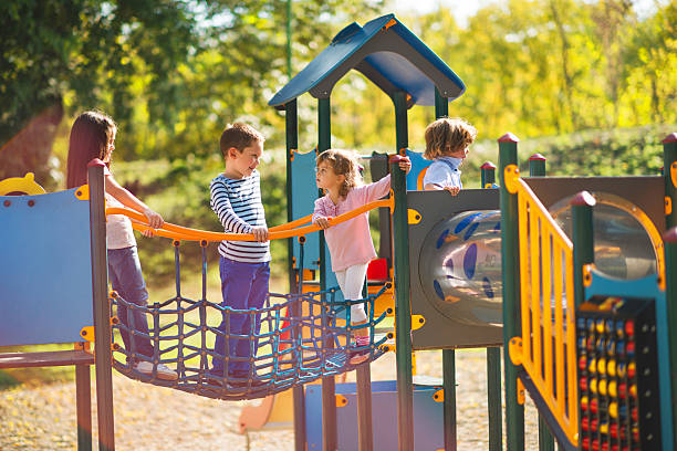 A colourful outdoor playground with slides and climbing frames among tropical trees