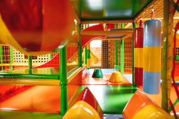 Kids play equipment with bright slides set in a sandy play area